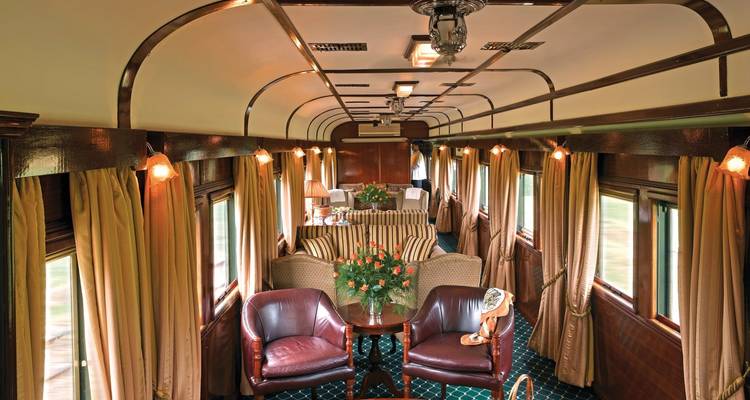 Loungebereich eines Luxuszuges mit Sitzgelegenheiten und Dekoration.