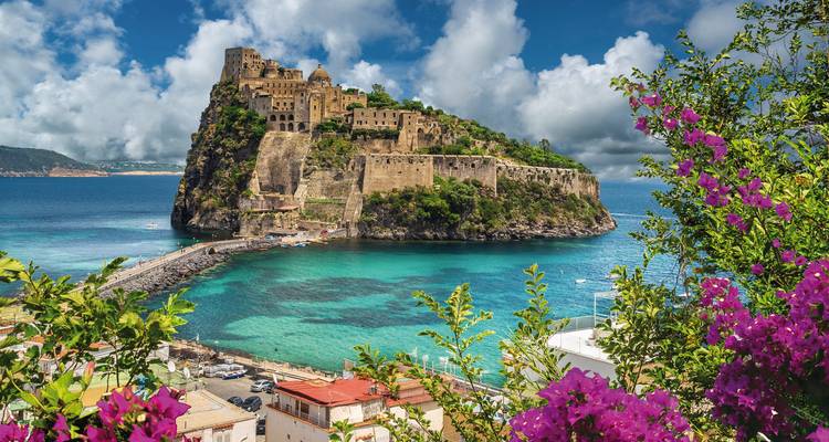 Schloss auf einer felsigen Insel umgeben von klarem blauen Wasser