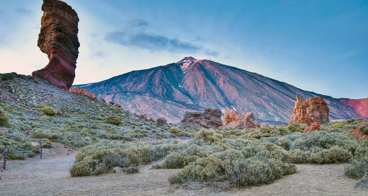 Randonneur admirant la vaste vue côtière et montagneuse.