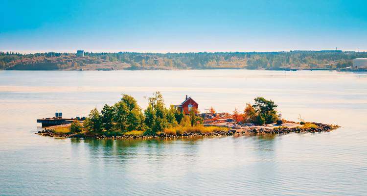 A small island with a red house surrounded by water