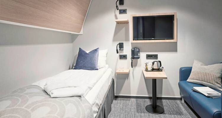 Cabine de bateau de croisière confortable avec un lit simple et des équipements modernes.