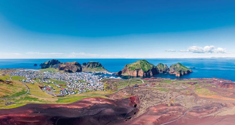 Malerischer Blick auf eine Küstenstadt, umgeben von lebendigen Landschaften.