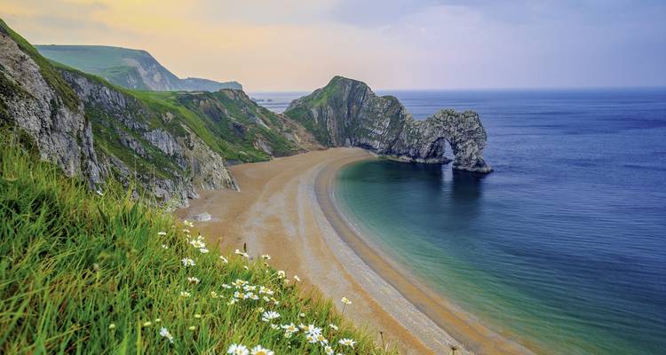 Falaise côtière avec une arche naturelle et vue sur la plage