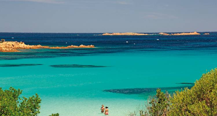 Two people standing in a turquoise sea.