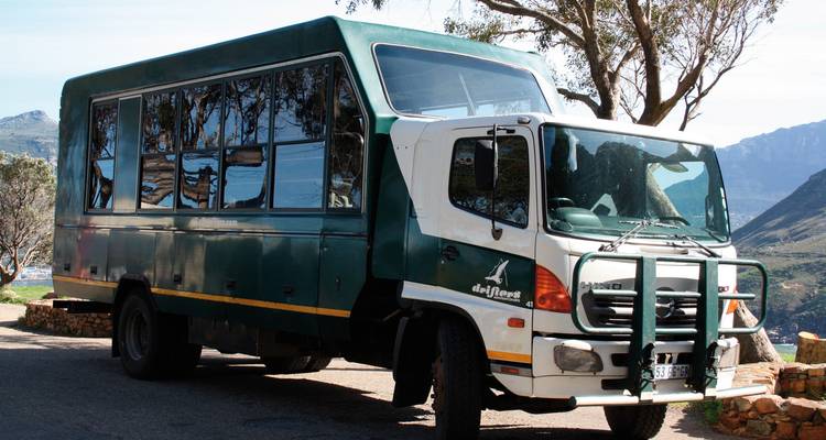 Vehículo de turismo estacionado a un lado de la carretera con fondo montañoso.