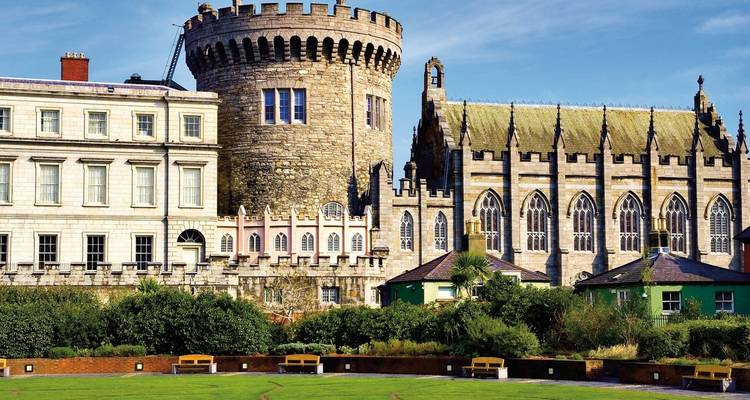 Historisches Schloss mit Gärten im Vordergrund.