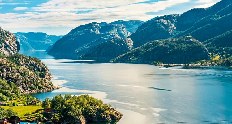 Un large fjord entouré de montagnes escarpées et d'un lac réfléchissant.