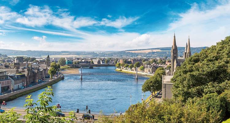 A riverside view of a city with prominent church spires.