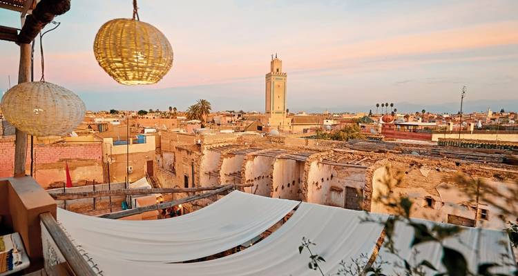Dachblick über Marrakesch mit einer Moschee und Sonnenuntergang.