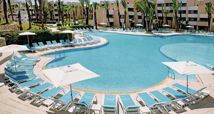 Rundes Schwimmbecken umgeben von Liegestühlen.