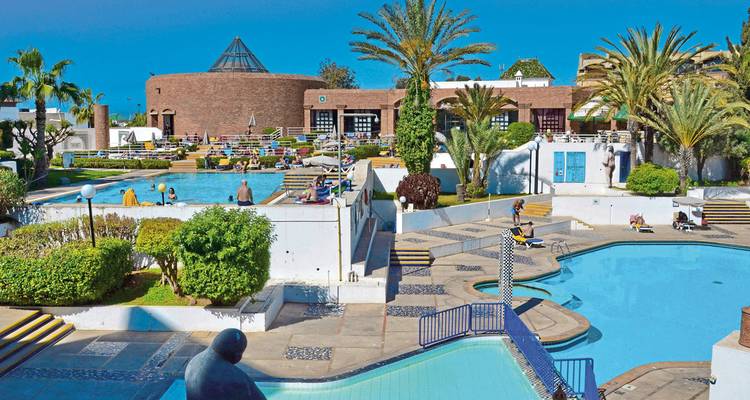 Hotelanlage-Poolbereich mit Sonnenliegen.