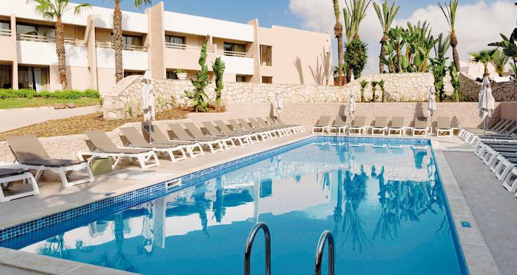 Poolbereich mit Sonnenliegen in einem modernen Hotel.