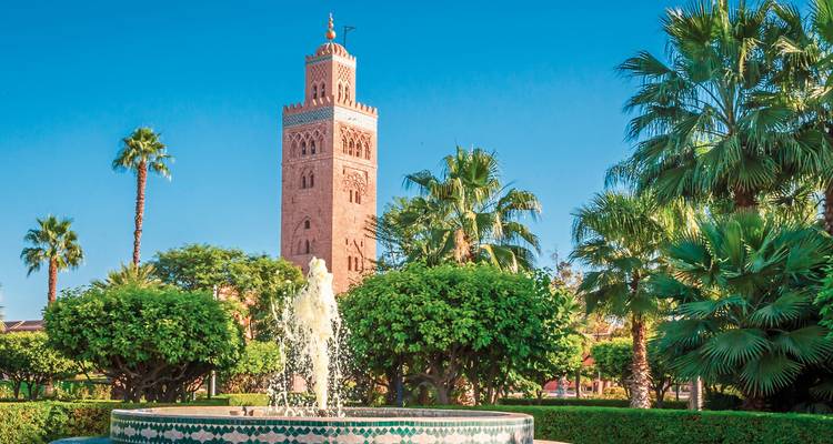 A towering minaret surrounded by lush gardens.