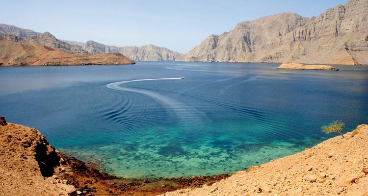Panoramisch uitzicht op een baai met boten en helder water.