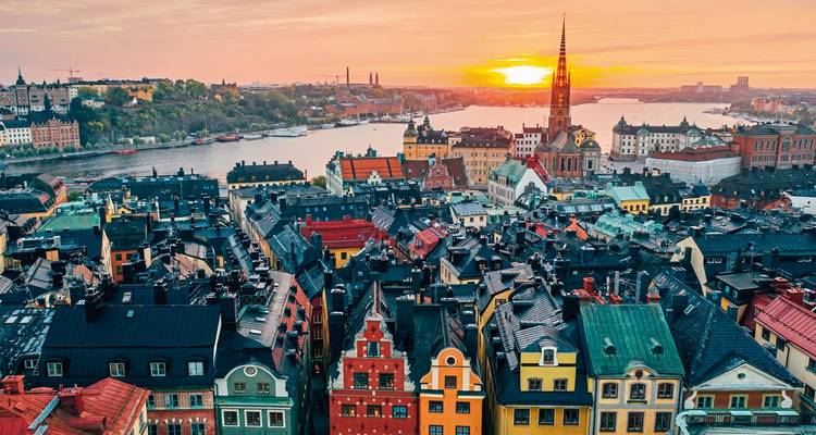 Aerial view of a colorful dense cityscape at sunset.