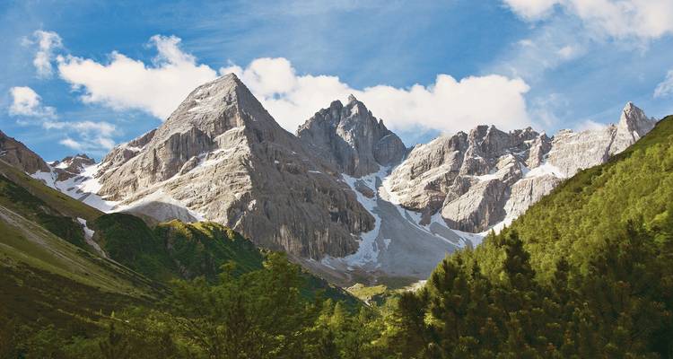 Majestueuze bergketen met besneeuwde toppen onder een heldere hemel.