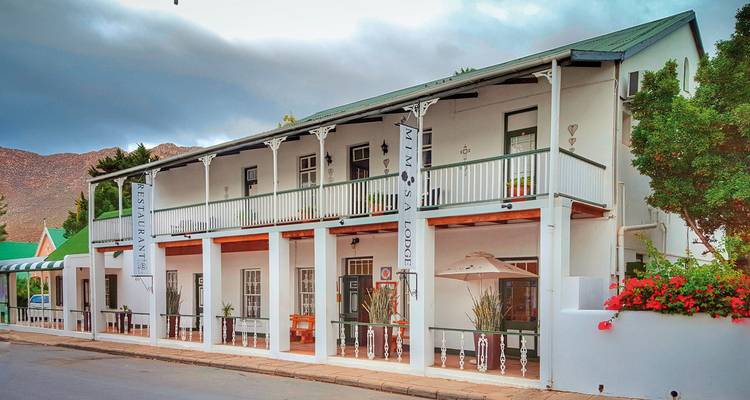 White colonial building with banners and flower decorations.