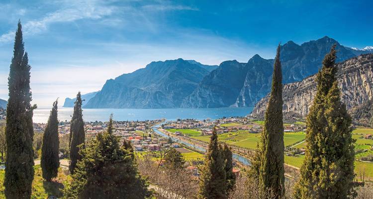 Ein malerischer Blick auf ein Tal und einen See, umgeben von Bergen.