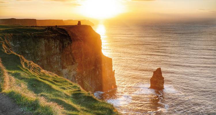 Vue du coucher de soleil sur les falaises de Moher avec un éclairage dramatique.