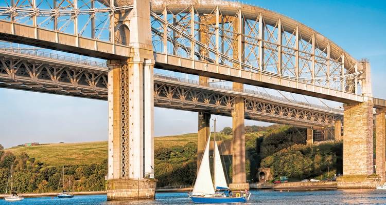 Un pont enjambant une rivière avec un voilier en dessous.