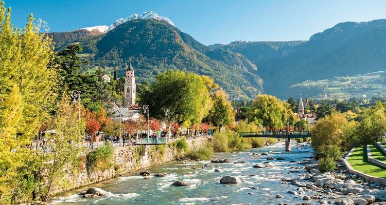 River with bridge and clock tower in the background, Italy.