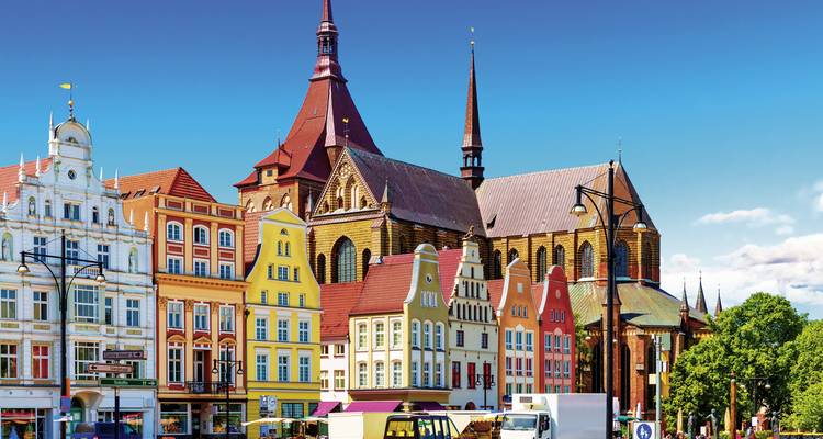 Colorful historic buildings and a church with spires.
