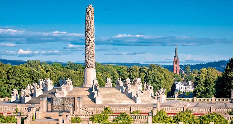 Vigeland Parks Skulptureninstallation an einem sonnigen Tag mit einer entfernten Kirche.