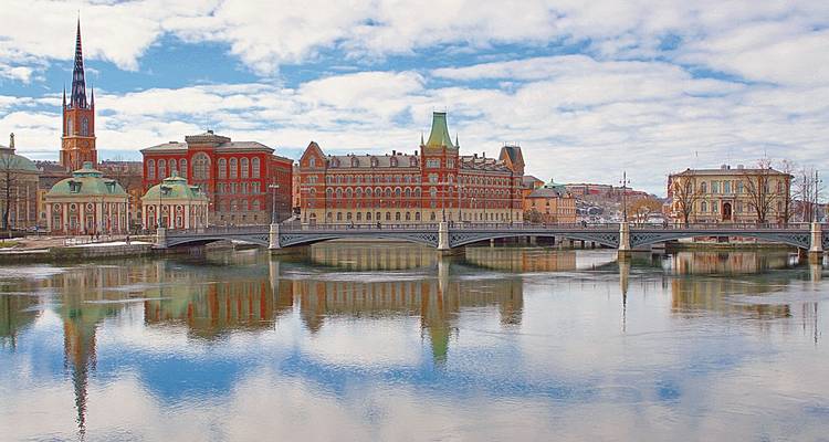 Paysage urbain avec un pont au-dessus d'une rivière calme.
