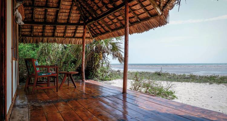 Strandterrasse mit Stühlen und Meerblick.
