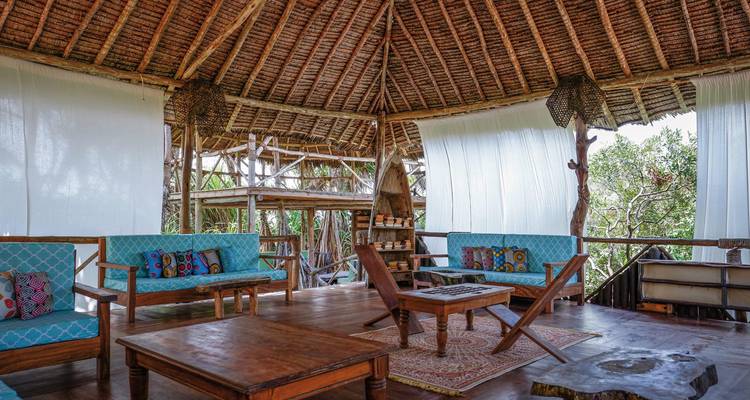 Rustikaler Loungebereich mit Reetdachkonstruktion.