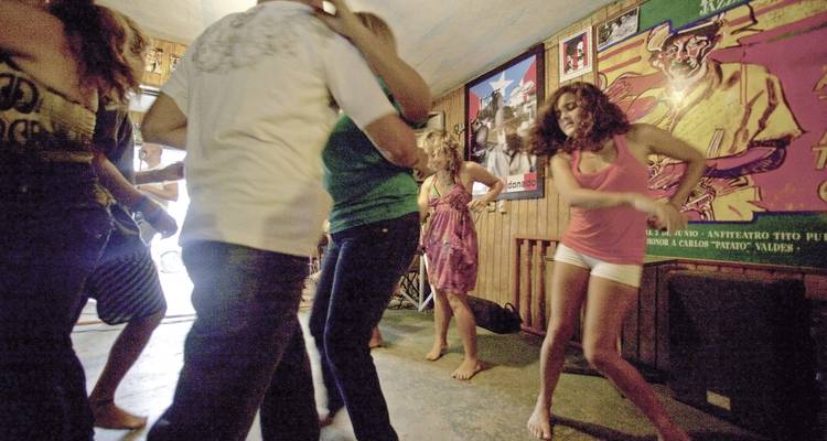 Mensen die dansen in een bar met posters aan de muur.