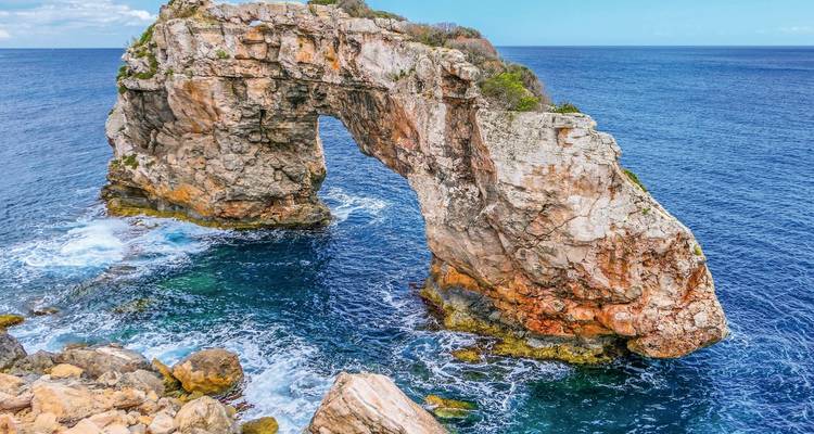 Formación de arco rocoso en el océano con olas estrellándose.