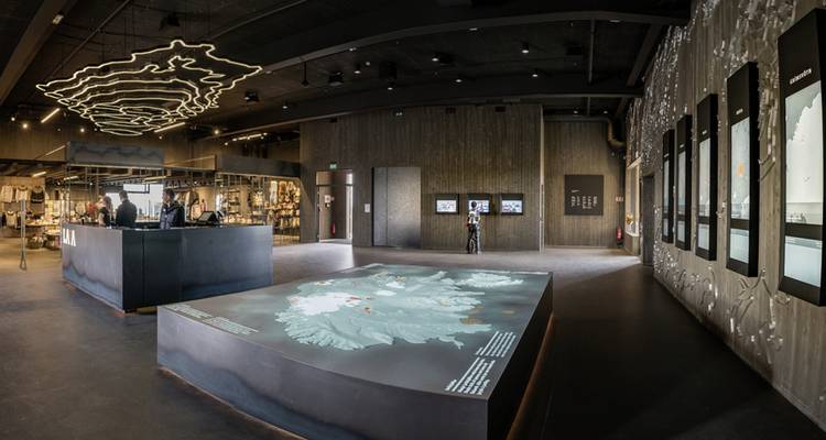 Interior de un museo con exhibiciones interactivas y mapas.