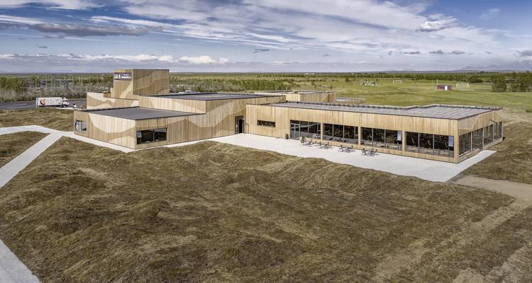Edificio moderno rodeado de paisaje abierto.