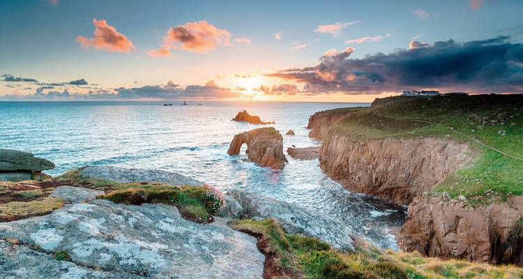 Dramatische Küstenklippen mit einem atemberaubenden Sonnenuntergang über dem Ozean.