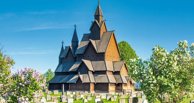 Historische Holzkirche umgeben von Grün.