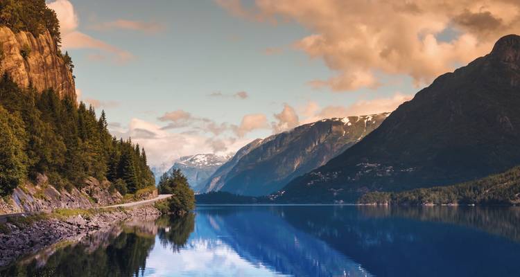 Tranquil fjord with steep mountain walls reflecting in the water.