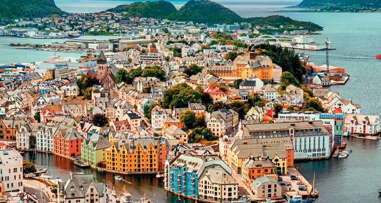Colorful houses in a coastal city with surrounding hills and boats.