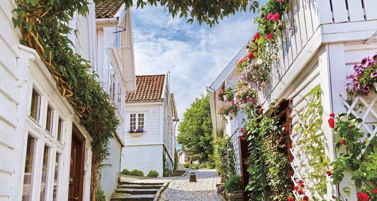 A picturesque street with white wooden houses and floral decoration.