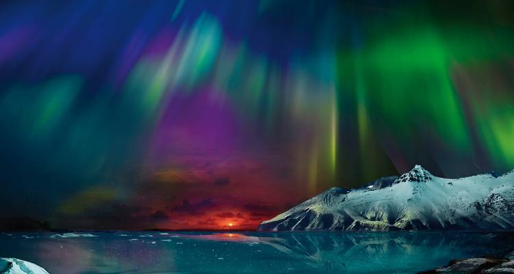 Levendige Aurora Borealis boven een besneeuwde berglandschap.
