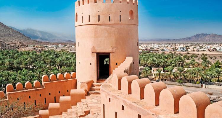 Historische Festung mit Panoramablick auf Palmenhaine und ein Dorf.