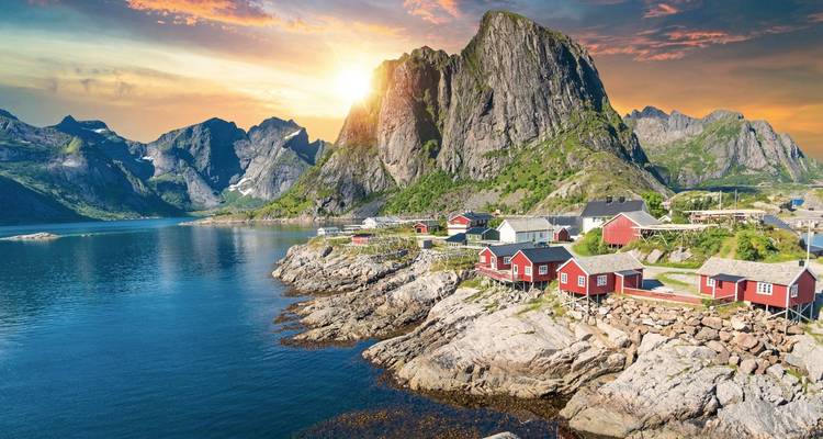 Vue pittoresque d'un fjord avec des cabanes rouges et une eau claire sous un ciel lumineux.