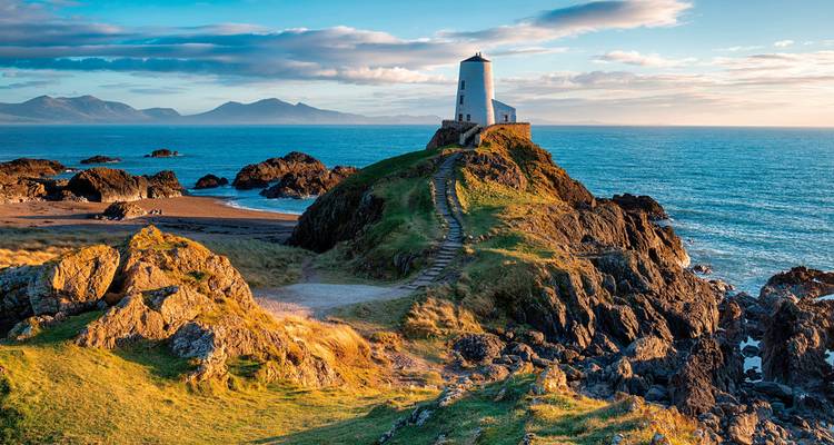 Lighthouse on a rocky hill overlooking the sea.