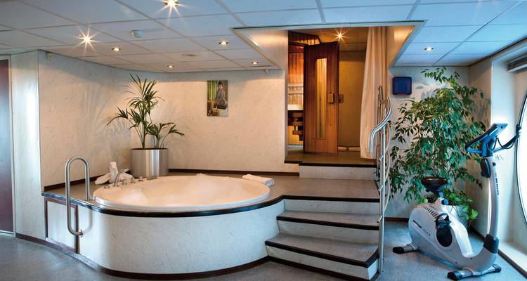 Espace spa sur un navire de croisière avec un jacuzzi et des équipements d'exercice.