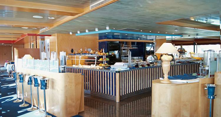 Innenraum eines Kreuzfahrtschiff-Speisebereichs mit Buffet und Sitzgelegenheiten.