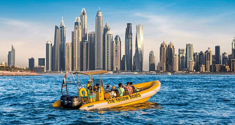 Touristenboot auf dem Wasser mit einer Skyline aus modernen Wolkenkratzern.