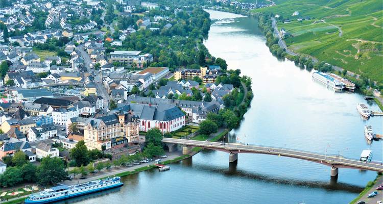 Luchtfoto van een schilderachtig stadje aan de rivier en groene velden.