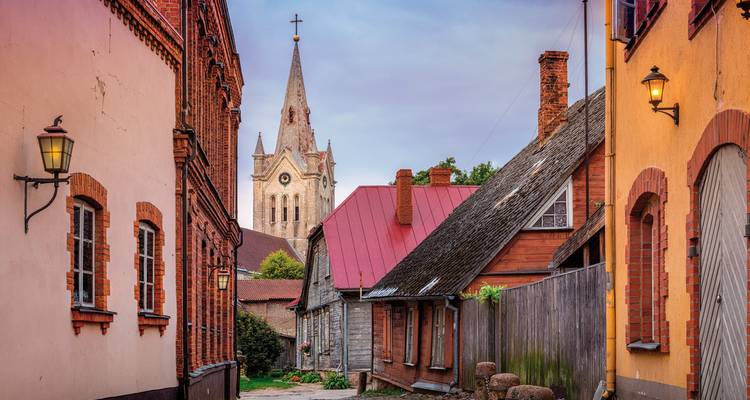 Une rue pittoresque dans un village avec une vieille église et des maisons traditionnelles.