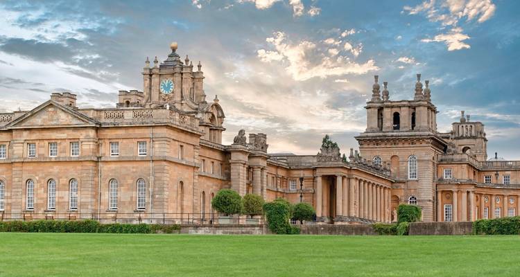 El impresionante Palacio de Blenheim se alza detrás de amplios y verdes jardines bajo un cielo espectacular.