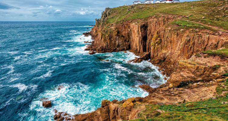 Las poderosas olas del Atlántico golpean los acantilados de granito de colores en Land's End.